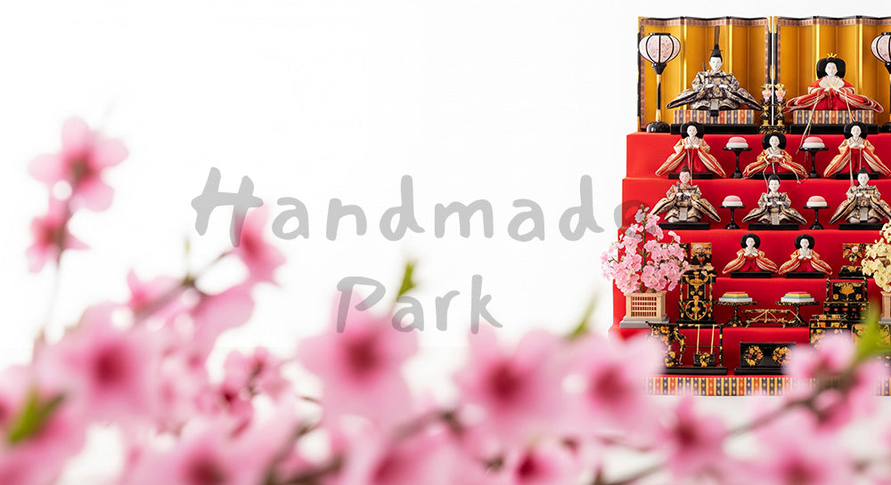 フリー素材 無料 写真｜前ボケ桃の花とひな段飾り 上部余白｜テキストを載せやすい余白背景