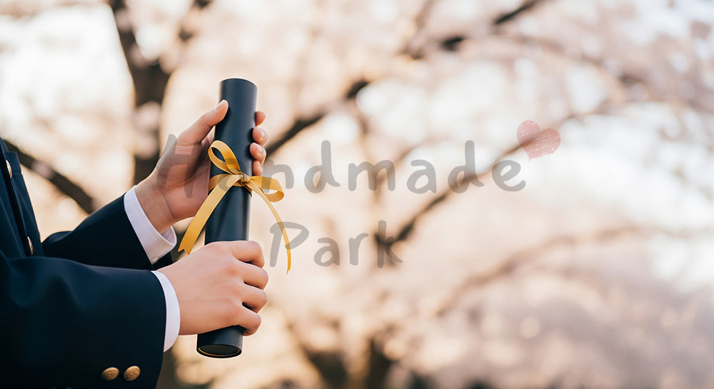 フリー素材 無料 写真|卒業証書筒を持つ日本人の手元 桜ボケ余白|テキストを載せやすい余白背景