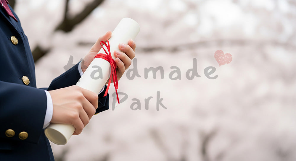 フリー素材 無料 写真|卒業証書筒を持つ日本人の手元 桜ボケ余白|テキストを載せやすい余白背景 (SNS向け)