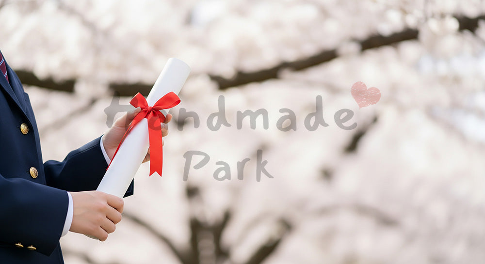 フリー素材 無料 写真|卒業証書筒を持つ日本人の手元 桜ボケ余白|余白たっぷりで見出しが入れやすい (特集向け)
